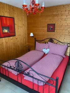 Un dormitorio con una cama con sábanas rosas y una lámpara de araña. en Ferienwohnung Allalinblick, en Saas-Fee