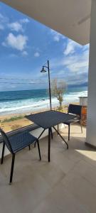 d'une table et de deux chaises sur un balcon donnant sur la plage. dans l'établissement Fronte mare, à Cala Gonone