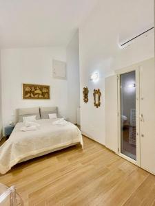 um quarto branco com uma cama e uma casa de banho em Home Viale Trento 16 em Cagliari