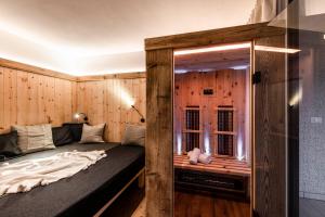 Posto letto in camera con parete in legno. di Bellevue Bruneck - Suites & Lofts a Brunico