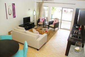 un soggiorno con 2 divani e un tavolo di Moana Sands Beachfront Villas a Rarotonga