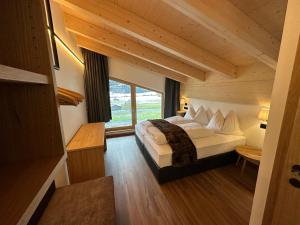 - une chambre avec un lit et une grande fenêtre dans l'établissement Pension Dorferwirt, à Bramberg am Wildkogel