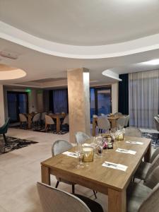 uma sala de jantar com uma mesa de madeira e cadeiras em Art's Luxury Boutique Hotel em Oradea