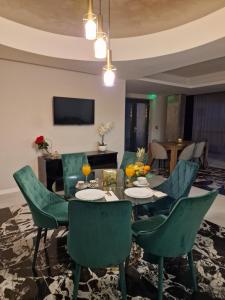 uma sala de jantar com cadeiras verdes e uma mesa em Art's Luxury Boutique Hotel em Oradea