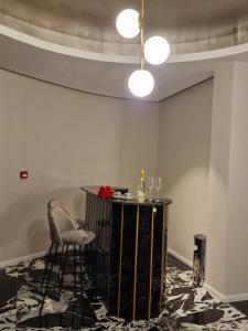 um bar numa sala com uma mesa e cadeiras em Art's Luxury Boutique Hotel em Oradea