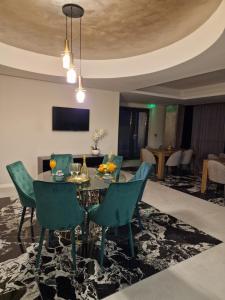 uma sala de jantar com uma mesa e cadeiras verdes em Art's Luxury Boutique Hotel em Oradea