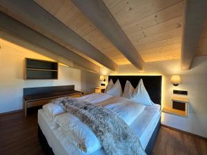 - une chambre avec un grand lit et un plafond en bois dans l'établissement Pension Dorferwirt, à Bramberg am Wildkogel