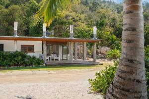 uma casa na praia com uma palmeira em Freedom Shores Resort Airlie Beach em Airlie Beach