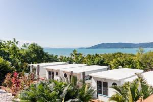 uma vista para uma casa com o oceano ao fundo em Freedom Shores Resort Airlie Beach em Airlie Beach