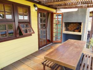 un patio con mesa de madera y chimenea en Un Sueño 2, en Punta del Diablo