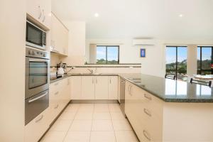 a kitchen with white cabinets and a counter top at Villa Franco Pet Friendly 10 Mins Walk to Beach in Surf Beach