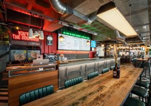 een restaurant met een lange houten tafel en stoelen bij BrewDog DogHouse Manchester in Manchester