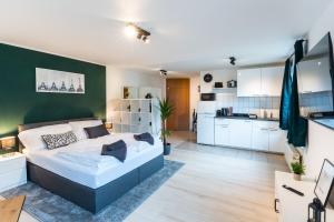 um quarto com uma cama e uma parede verde em Mercedes I Stuttgart I Kitchen I Home Office I Parkplatz em Böblingen