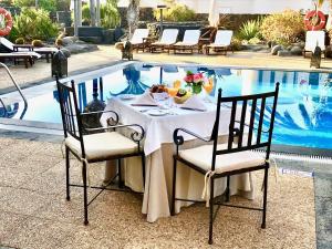 une table en face d'une piscine dans l'établissement Villa VIK - Hotel Boutique, à Arrecife