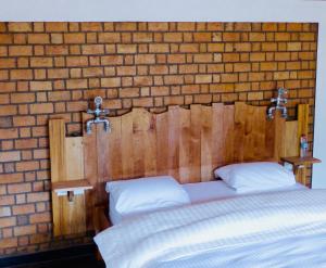 - une chambre avec une tête de lit en bois et 2 lits dans l'établissement Le Chat'o Park Hotel Ivato Airport NAVETTE GRATUITE H24, à Antananarivo