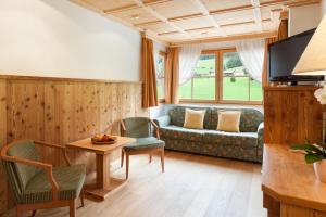 a living room with a couch and a table at Hotel Chalet Tianes - Alpine Relax in Castelrotto