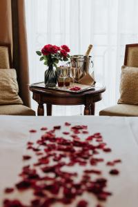 a table with two glasses and a vase with flowers on it at Hotel Le Plaza Brussels in Brussels