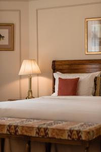 a bedroom with a bed with a lamp on a table at Hotel Le Plaza Brussels in Brussels