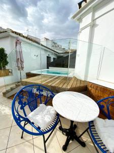 un patio con tavolo e sedie sul balcone. di Casa Bailen Sevilla a Siviglia