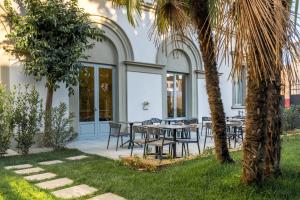 een patio met tafels en stoelen en een palmboom bij Hotel Ariele in Florence