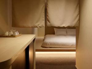 a bedroom with a bed and a desk with a bed sidx sidx sidx at SOKI Kanazawa in Kanazawa