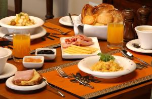 uma mesa coberta com pratos de comida e pão em Hotel Colonial Blanco em Santo Domingo