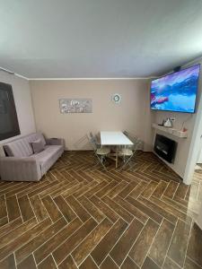 a living room with a couch and a table and a flat screen tv at Grange chic in Sestriere