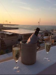 una botella de champán en un cubo de hielo sobre una mesa con dos copas en FONTEblu B&B, en Polignano a Mare