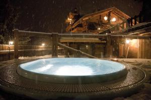 een hot tub in de sneeuw voor een hut bij Chalet-hotel Svizzero in Courmayeur