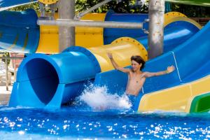 un hombre deslizándose por un tobogán de agua en el agua en Prestige Hotel and Aquapark - All inclusive, en Golden Sands