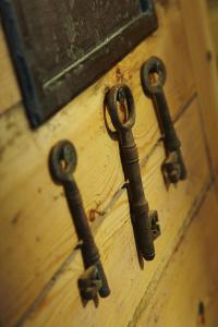 a group of old rusty keys hanging on a door at Hang Your Hat in Winchester