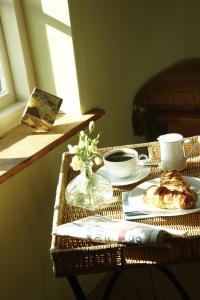 a rattan table with a coffee cup and a plate of food at Hang Your Hat in Winchester