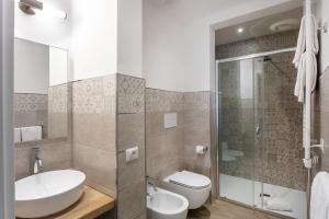 La salle de bains est pourvue d'un lavabo, de toilettes et d'une douche. dans l'établissement Lungomare Rooms, à Olbia