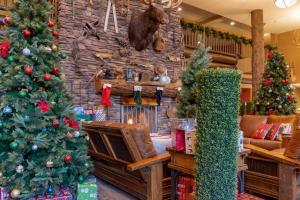 a living room with christmas trees and a fireplace at The Grand Hotel at the Grand Canyon in Tusayan