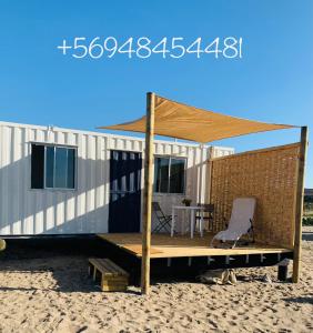 une maison sur la plage avec une table et une chaise dans l'établissement Cabañas ecológicas Tongoy, à Tongoy