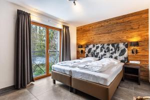 Schlafzimmer mit einem Bett, einem Schreibtisch und einem Fenster in der Unterkunft Mountain Lodge Leogang - Top4 in Leogang