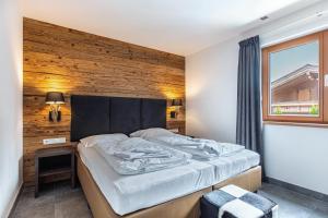 ein Schlafzimmer mit einem großen Bett und einer Holzwand in der Unterkunft Mountain Lodge Leogang - Top4 in Leogang