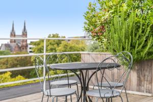 een tafel en stoelen op een balkon met uitzicht bij Fuths Penthouse 55 in Antwerpen