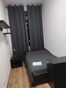 Schlafzimmer mit einem Bett und einem Fenster mit schwarzen Vorhängen in der Unterkunft Centro Hostel in Vilnius