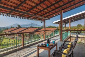 uma vista da varanda de uma casa em SaffronStays Lake House Bouganvillea, Nashik - rustic pool villa with great lake views and patio dining em Nashik