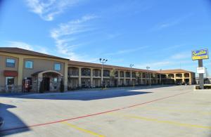 an empty parking lot in front of a building at Scottish Inns Fort Worth in Fort Worth