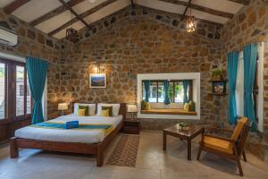 um quarto com uma cama num quarto com paredes de pedra em SaffronStays Lake House Marigold, Nashik - rustic cottages with private plunge pool em Nashik