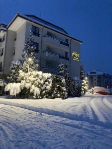 ein Gebäude mit Schnee auf dem Boden davor in der Unterkunft Parklands Hotel & Pool in Bansko