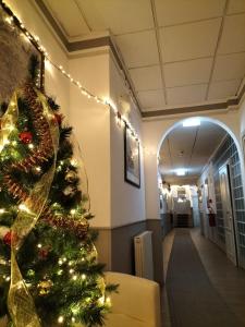 Un árbol de Navidad en un pasillo del hospital con luces en Hotel Camilla Firenze, en Florencia