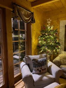 ein Wohnzimmer mit einem Weihnachtsbaum und einer Couch in der Unterkunft Domki Pasja II 2,5 km do wyciągu naciarskiego Czorsztyn Ski in Kluszkowce