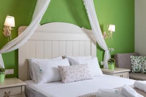 um quarto com uma cama branca e paredes verdes em Villa Anthelion em Limenaria