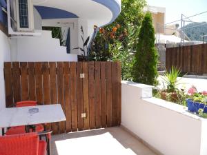 un patio con una valla de madera y una mesa en Blue Sea Beach Resort, en Skala Potamias