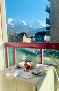 uma mesa numa varanda com vista para uma montanha em Appartement CITY CENTER-SALLANCHES em Sallanches