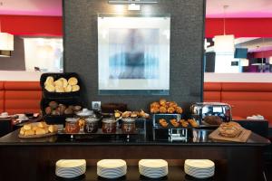 una línea de buffet con varios tipos de pan y repostería en SANA Capitol Hotel, en Lisboa