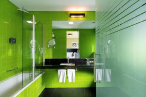 baño verde con ducha y lavamanos en SANA Capitol Hotel, en Lisboa